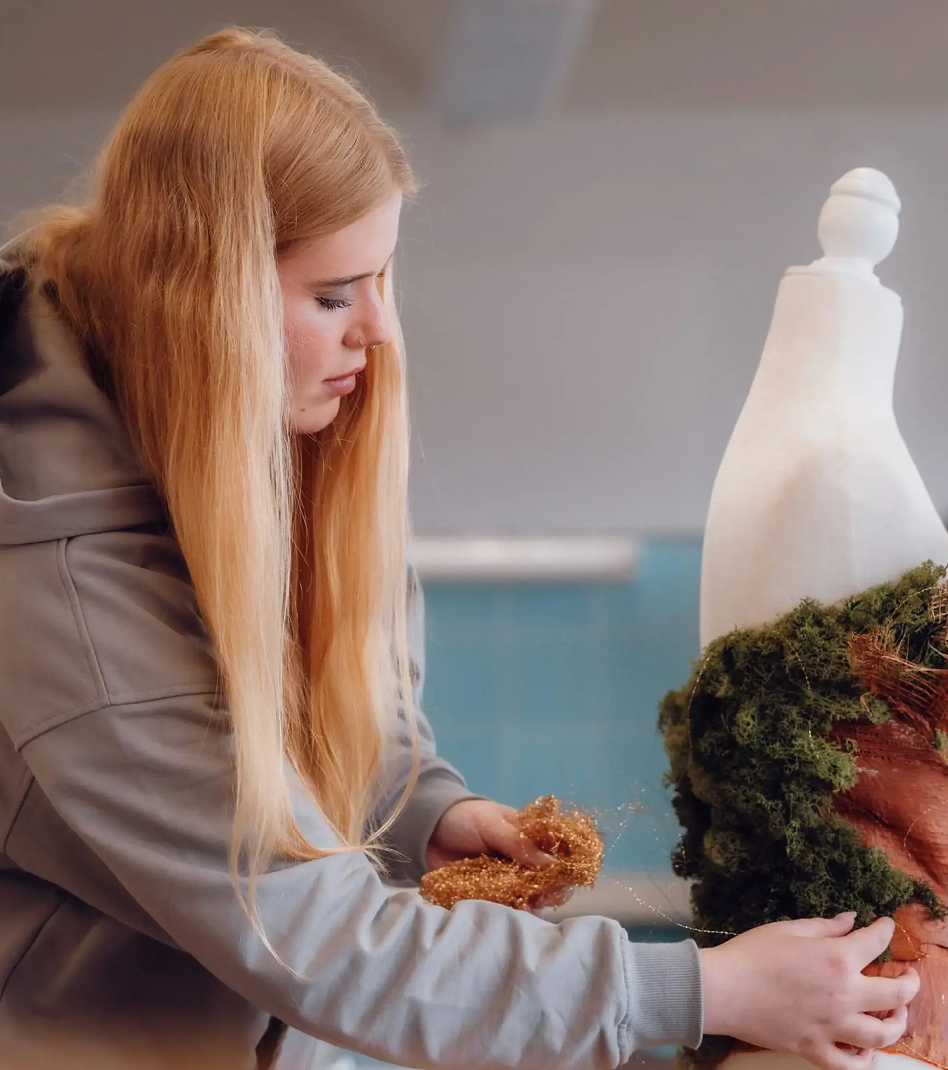 Student in sewing class decorating a dress
