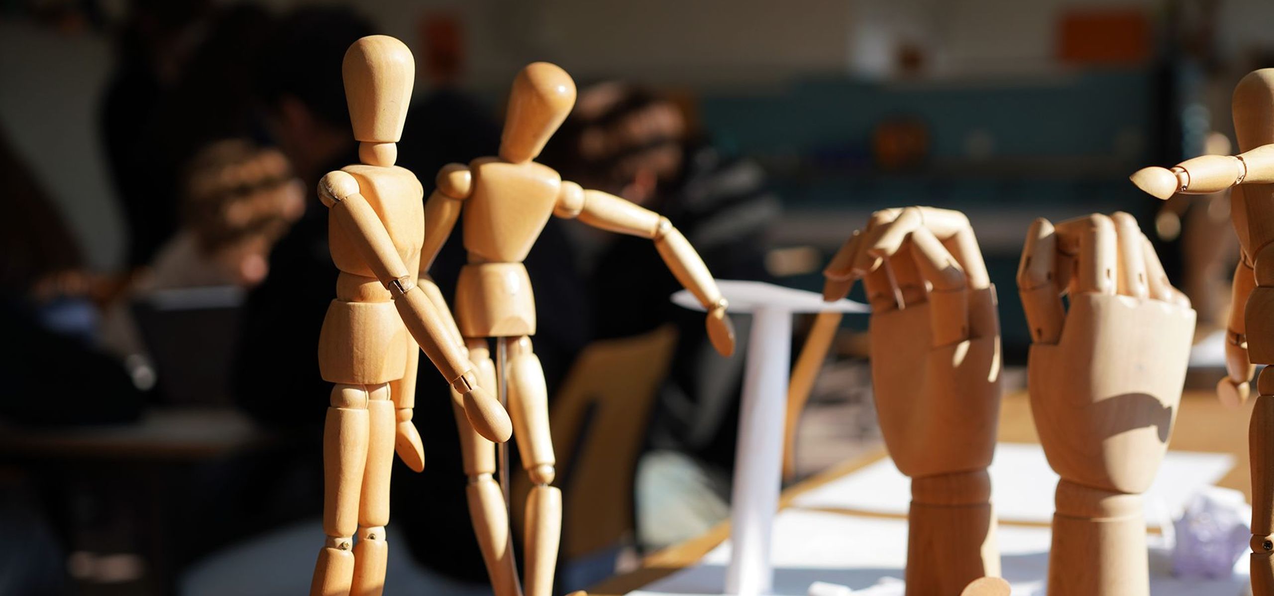 Wooden artist mannequins posed on a table in an art classroom