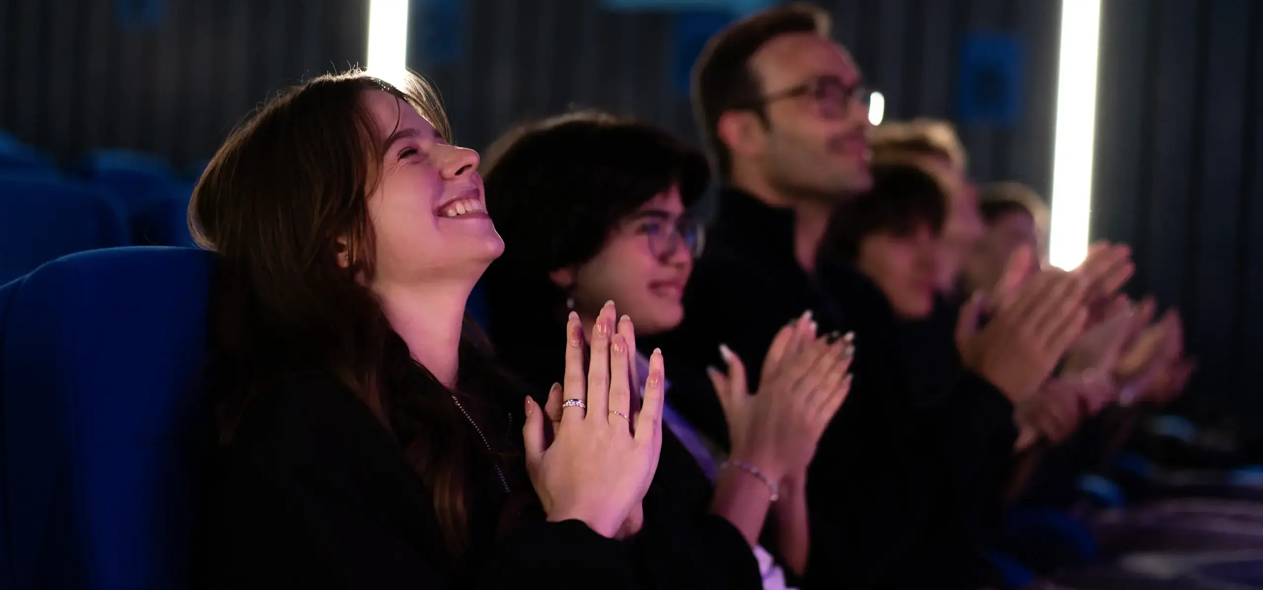 Students clapping in an auditorium 