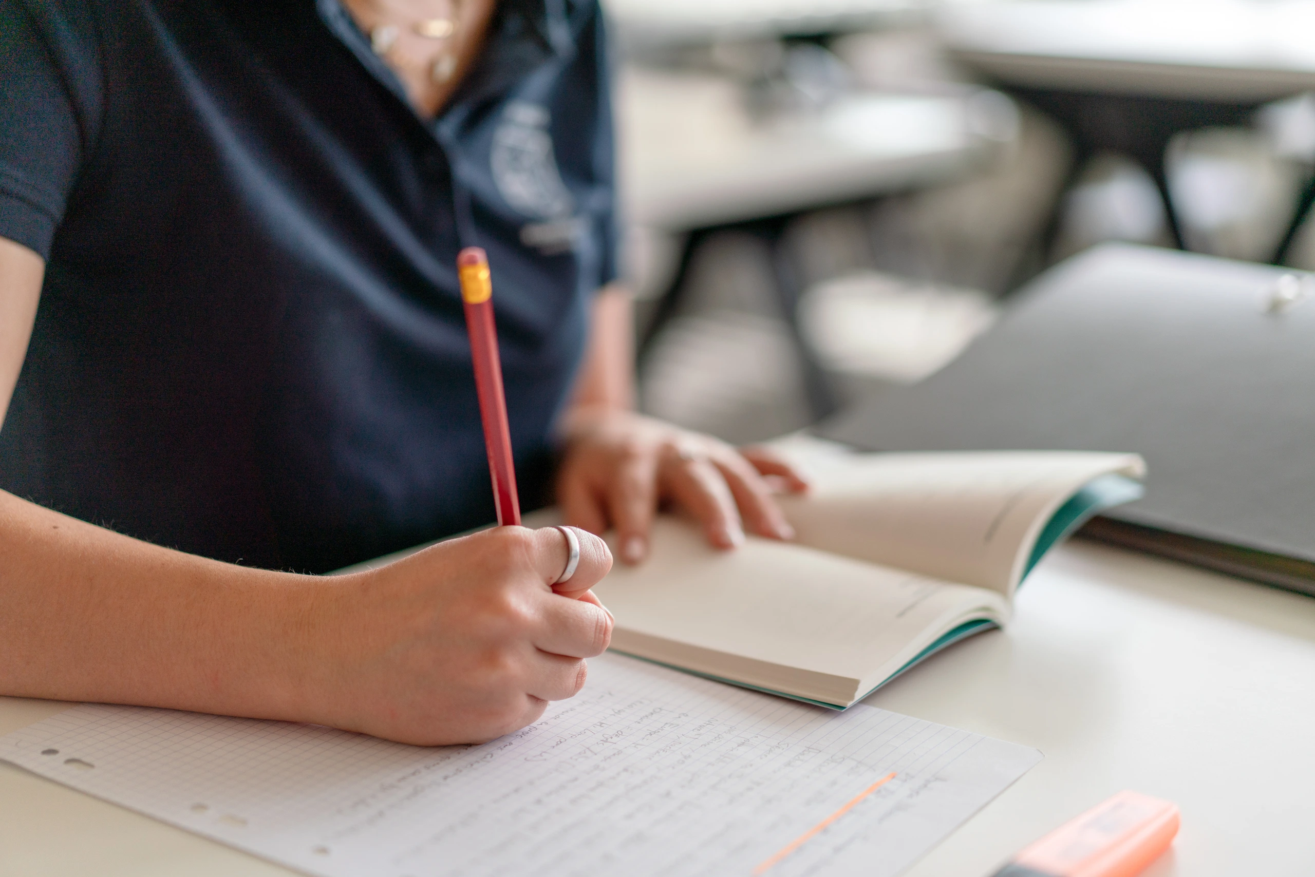 Student writing on a notebook