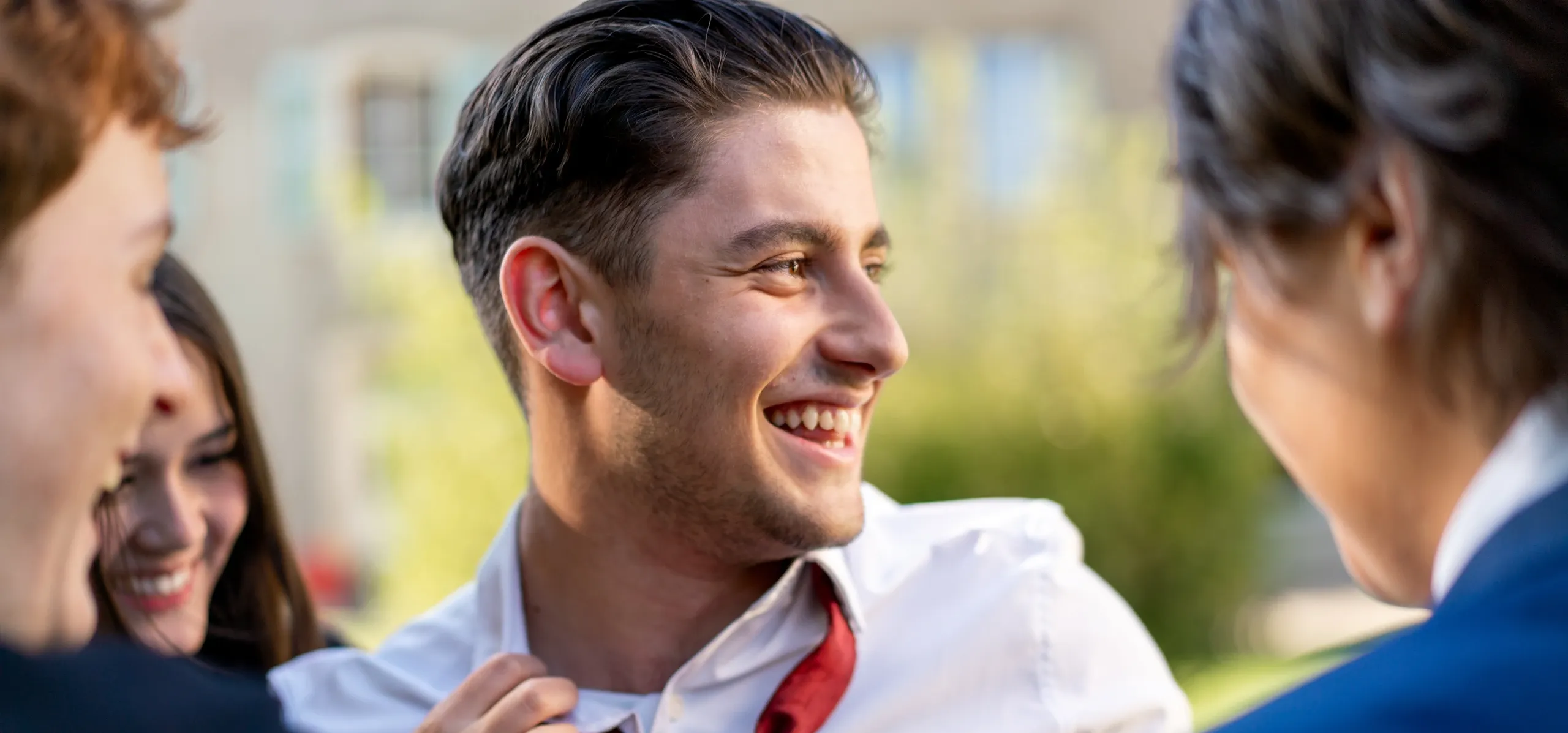 Parent helping her son with his tie before graduation